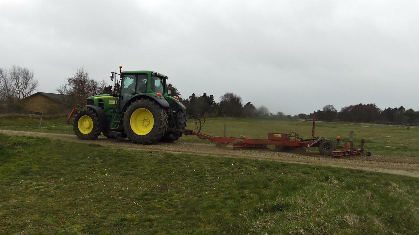 Traktor bei der Instandhaltung eines Schotterwegs (Beispielfoto)